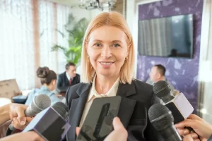 Smiling woman surrounded by microphones and other recording devices